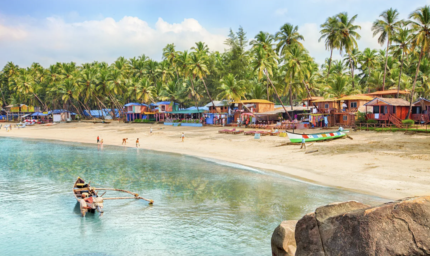Palm-fringed Patnem Beach in South Goa with turquoise water and colourful beach huts